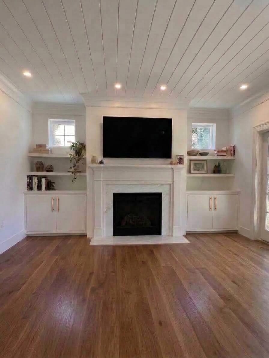 Fireplace flanked by matching built-in cabinetry with floating shelves, Marble Island, Colchester, Vermont