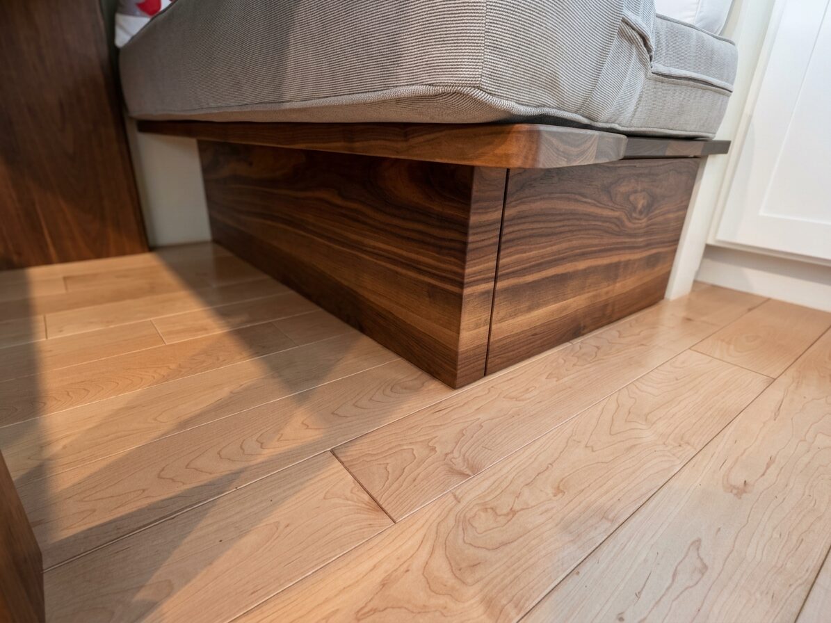 Walnut storage base under the banquette seating with a soft-close pullout drawer