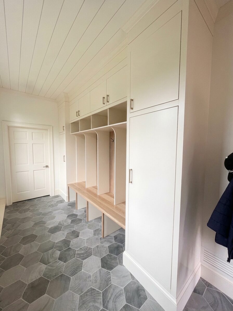 Mudroom built-in viewed from the hallway, with painted cabinetry above